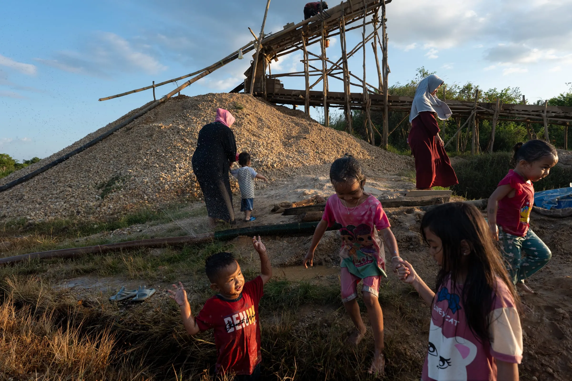 The mining pit turns into a playground during Indonesia’s National Day holiday. Miners’ wives come with their children to play among the water hoses and muddy terrain. Even on public holidays, miners like Amin and Esol keep working — every extra day may bring the chance of a find.