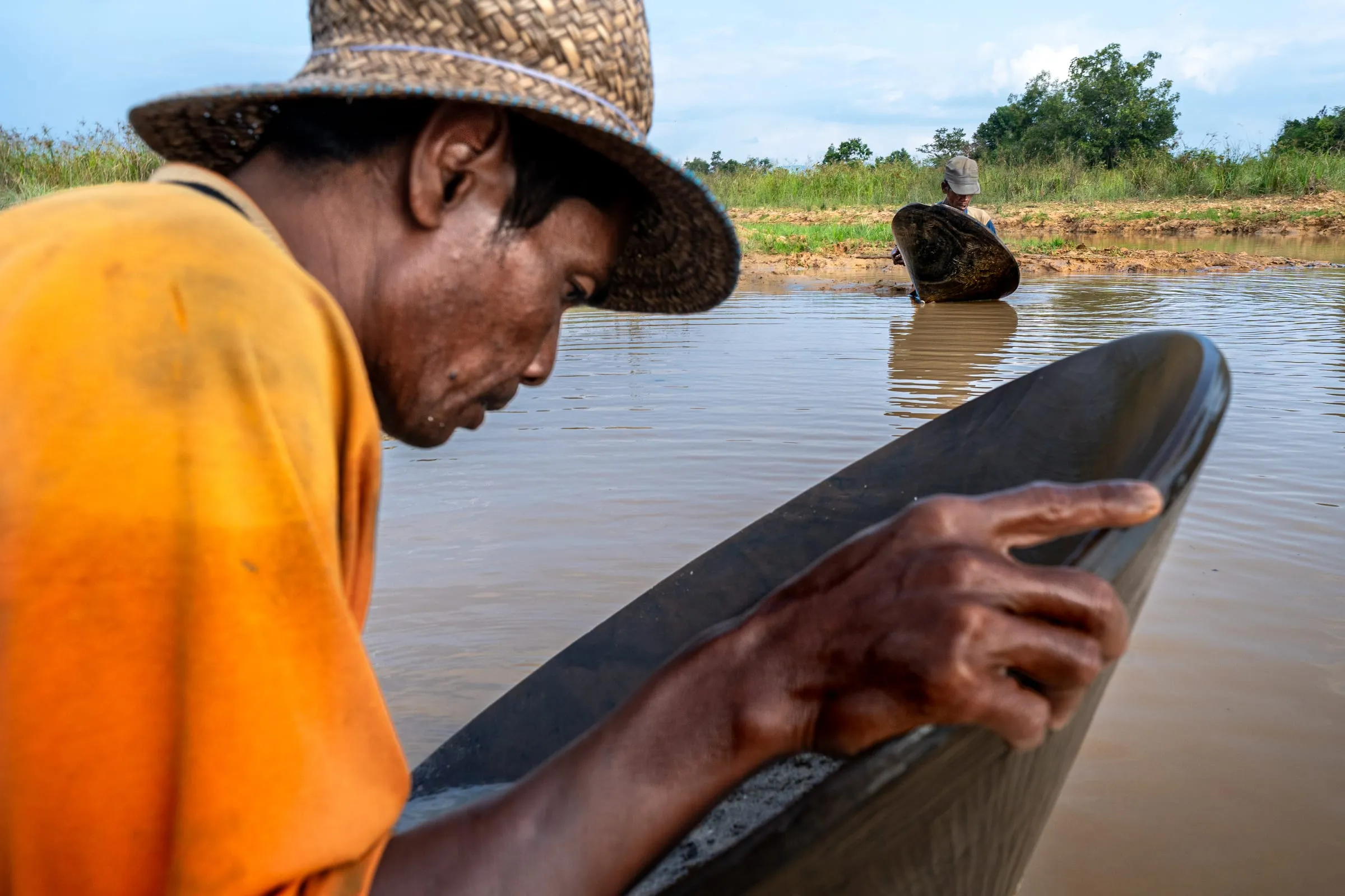 Anang, 35, and Adai, 47, wash gravel in their dulangs — ironwood pans used to separate diamonds from sand and clay. The work, done entirely by hand, requires patience and precision. Miners say it now takes weeks to find what once could be found in days.