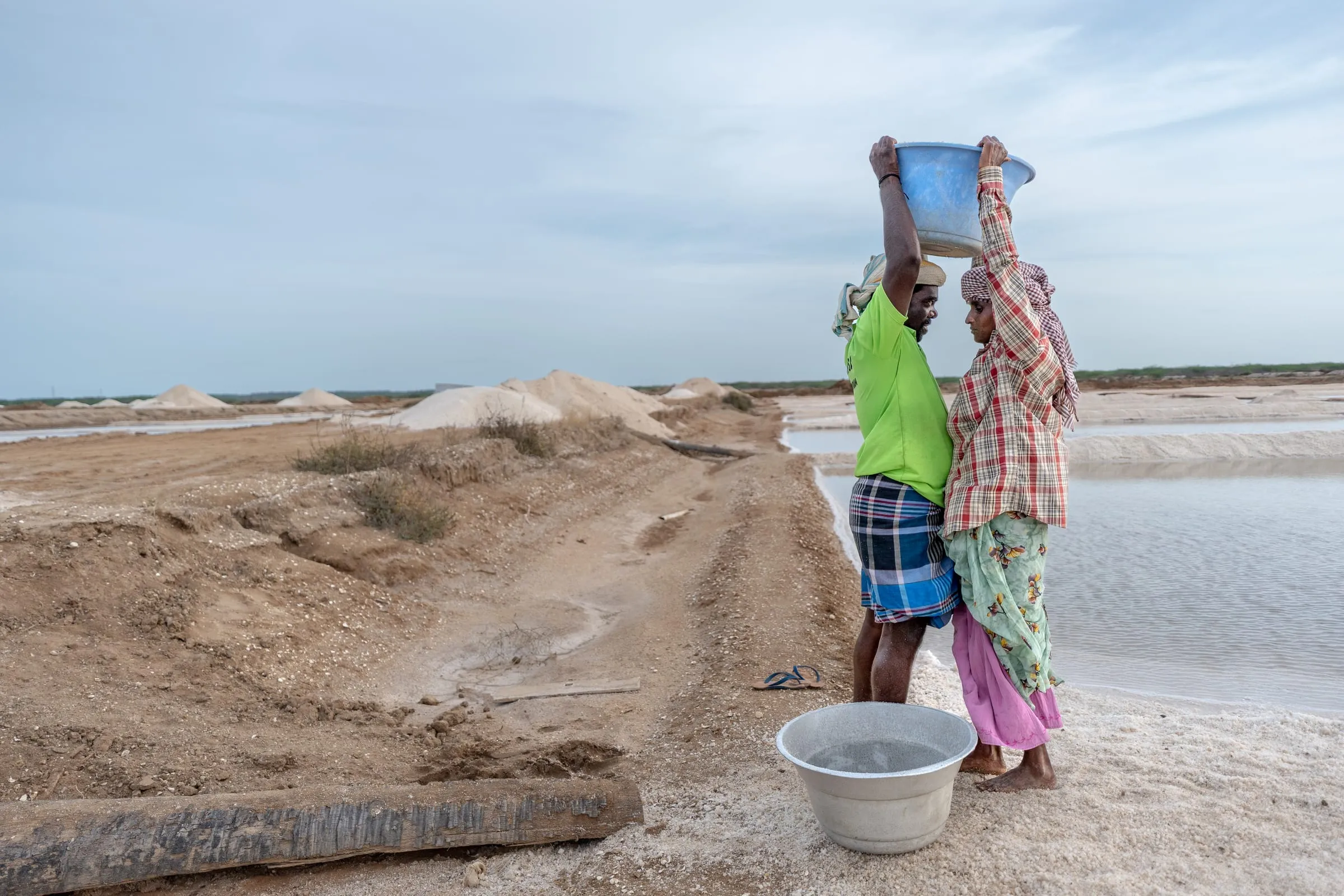 Women and men perform the same tasks in the salt pans of Thiruppullani, Tamil Nadu, India, yet women are often paid less per day. Wages are seasonal, typically ranging from 250 to 350 rupees (approximately USD 3–4.50), depending on the type of work. Most workers are employed without formal contracts.