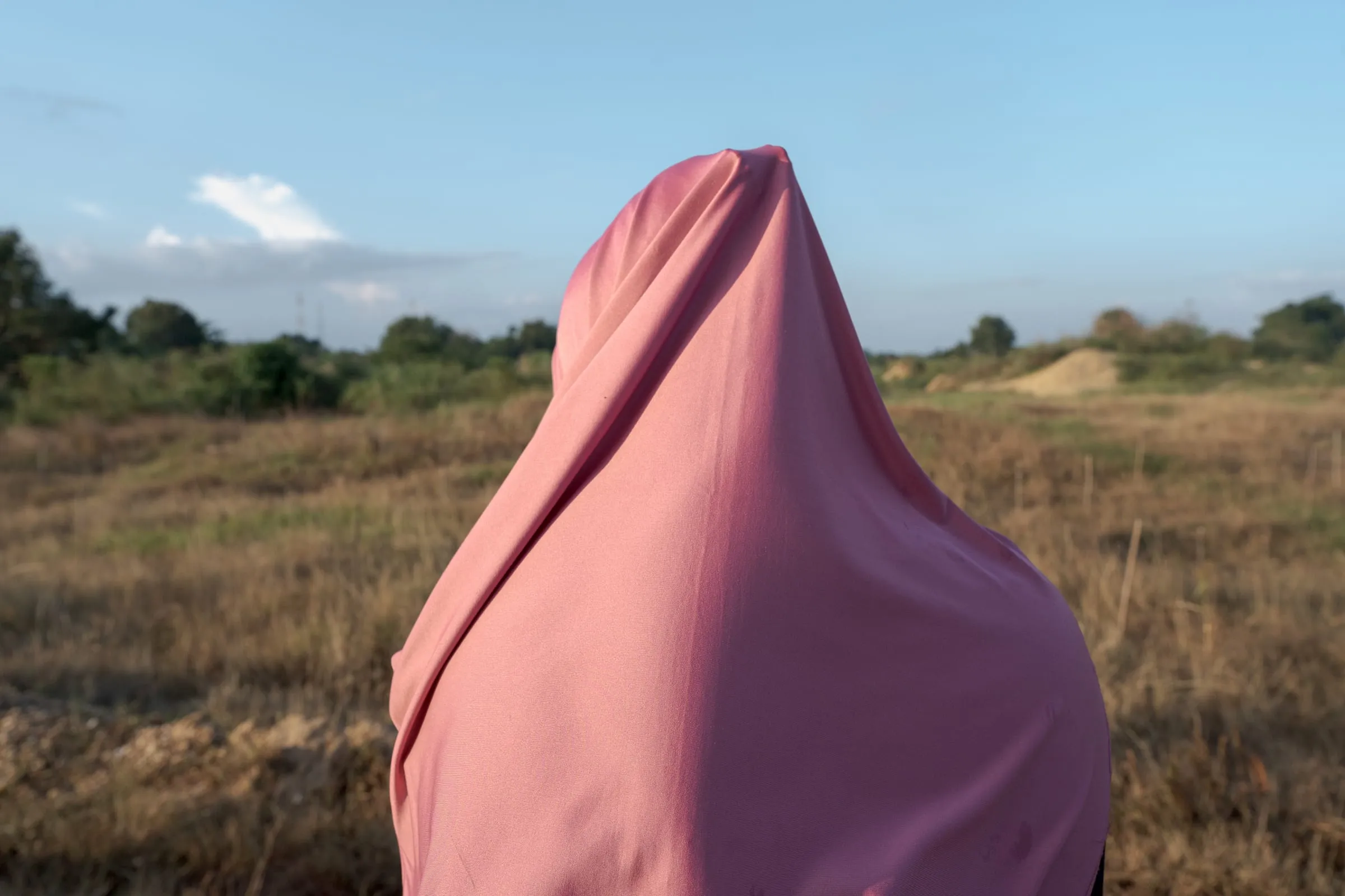 A woman watches the Cempaka mining fields at dusk. The Indonesian government plans to convert the area into an educational tourist site to reduce risks and provide alternative livelihoods for local communities.