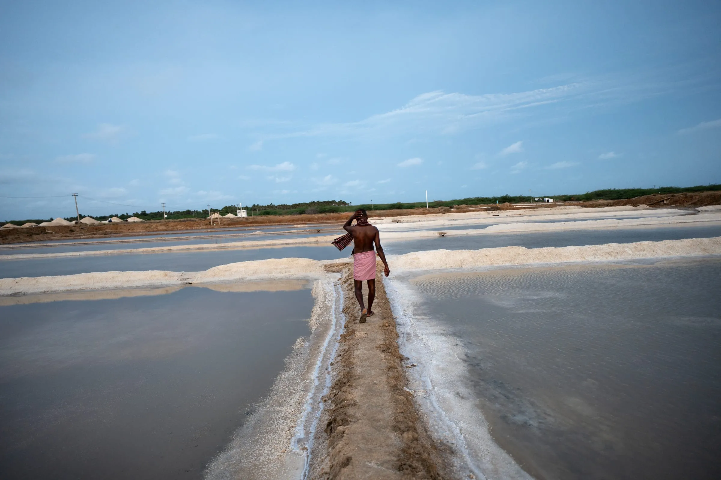 Murugavel, 45, finishes his shift at the salt pans in Thiruppullani, Tamil Nadu, India. Shifts typically begin at 6:00 a.m. and end around 3:00 p.m., with workers exposed to extreme heat and little to no shade. Murugavel has been working in the salt pans for 27 years. He lives in Valinokkam village, about an hour away by rickshaw.